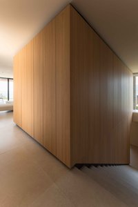 Moderne Holzverkleidung über einer offenen Treppe im hellen Innenraum