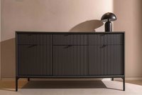 Schwarzes Sideboard mit geriffelter Front und Tischlampe vor rosafarbener Wand