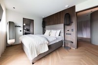 Modernes Schlafzimmer mit Doppelbett, Holzakzenten und minimalistischem Design