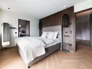 Modernes Schlafzimmer mit Doppelbett, Holzakzenten und minimalistischem Design