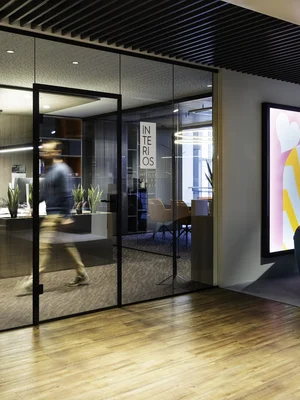 Moderner Bürobereich mit Glaswänden, Arbeitsplatz und Sitzbereich