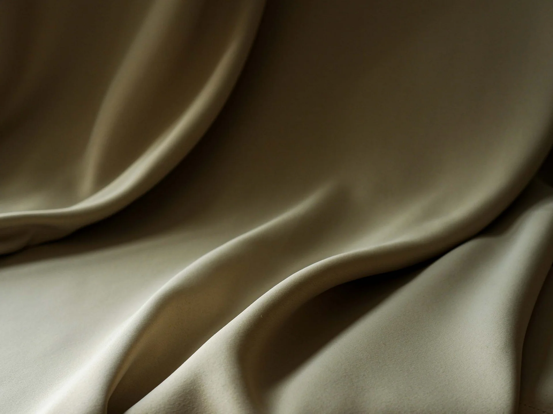 INTERIOS. Il tuo studio di interior design. Primo piano di tessuto beige piegato con morbide pieghe