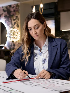 Donna che segna planimetrie con righello in ufficio moderno