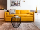 Gelbes Sofa mit Kissen und Büchern auf schwarzen Drahttisch im Wohnzimmer