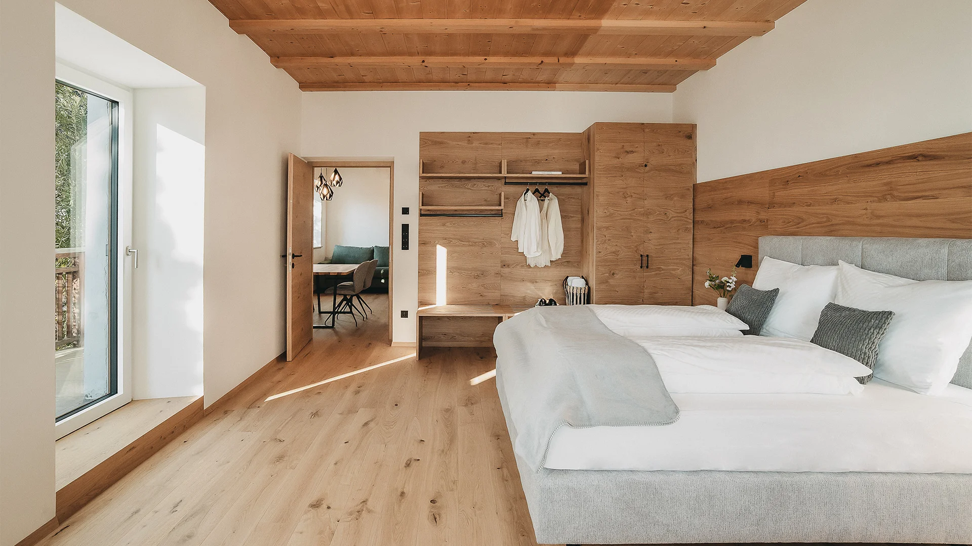 Camera da letto moderna con pavimento, soffitto e mobili in legno, letto grande e finestra