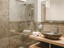 Bagno moderno con doccia in vetro e lavabo in pietra naturale