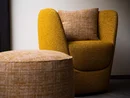 Gelber Sessel mit passendem Hocker und Kissen in modernem Raum