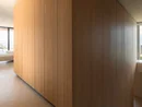 INTERIOS. Il tuo studio di interior design. Interno moderno con grande pannello in legno e scala