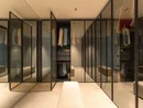 INTERIOS. Il tuo studio di interior design. Cabina armadio con ante in vetro, abiti e panca
