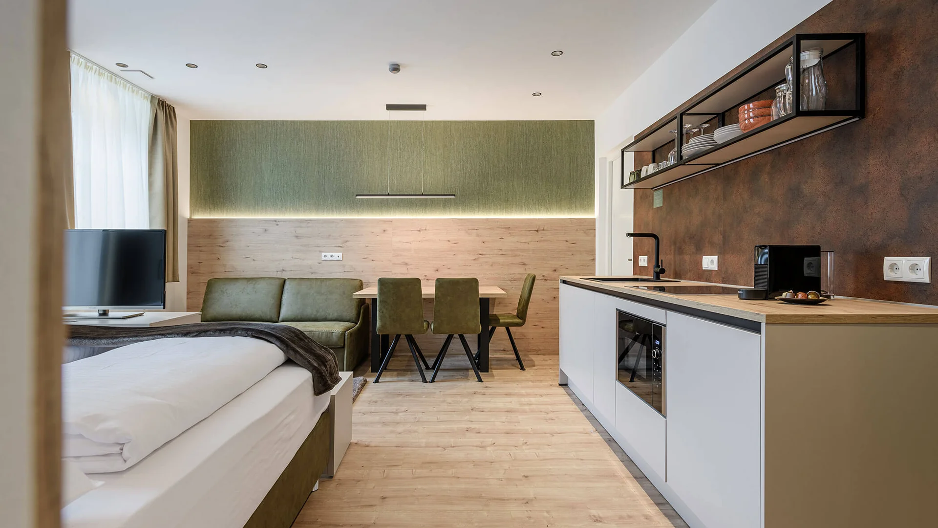 Moderner Wohnbereich mit Küche, Essplatz und Sofa in neutralen Farben