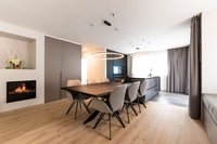 Moderner Essbereich mit großem Holztisch, sechs Stühlen und integriertem Kamin