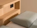 INTERIOS. Il tuo studio di interior design. Letto con biancheria verde chiaro, cuscino e testiera in legno con vano a giorno