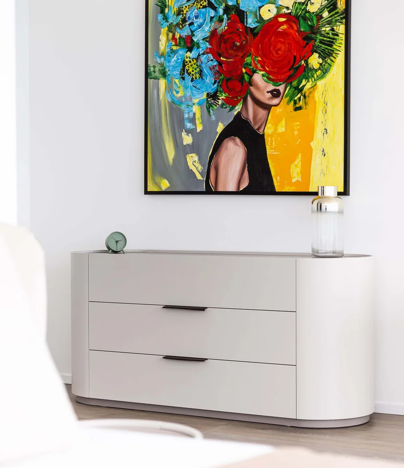 Moderner Raum mit abstraktem Blumenporträt über grauer Kommode