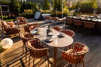 Moderne Terrasse mit Esstisch und Lounge-Möbeln bei Sonnenuntergang