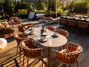 Moderne Terrasse mit Esstisch und Lounge-Möbeln bei Sonnenuntergang