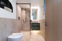 Modernes Badezimmer mit begehbarer Dusche und Bidet in neutralen Farben