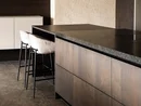 Moderne Kücheninsel mit Holzfronten und zwei gepolsterten Barhockern