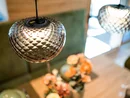 Nahaufnahme einer glänzenden, hängenden Glühlampe mit unscharfem Hintergrund