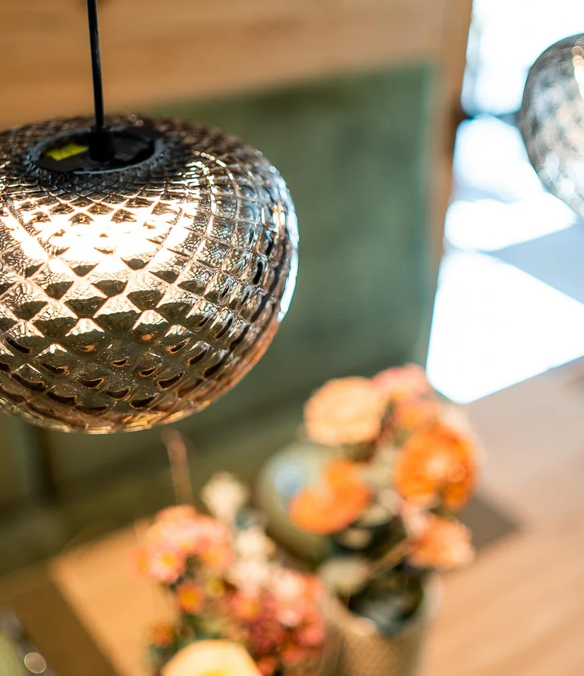 Nahaufnahme einer glänzenden, hängenden Glühlampe mit unscharfem Hintergrund