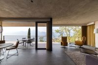 Moderner Wohnraum mit großen Fenstern und Blick auf Terrasse und Berge