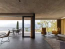 Moderner Wohnraum mit großen Fenstern und Blick auf Terrasse und Berge