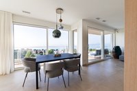 Moderner Essbereich mit Tisch, Stühlen und Panoramablick auf die Natur