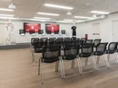 Konferenzraum mit schwarzen Stühlen und Präsentationsbereich mit Fußballtrikots