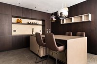 Moderne Küche mit dunklen Holzschränken und zwei braunen Barhockern