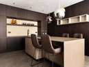 Moderne Küche mit dunklen Holzschränken und zwei braunen Barhockern