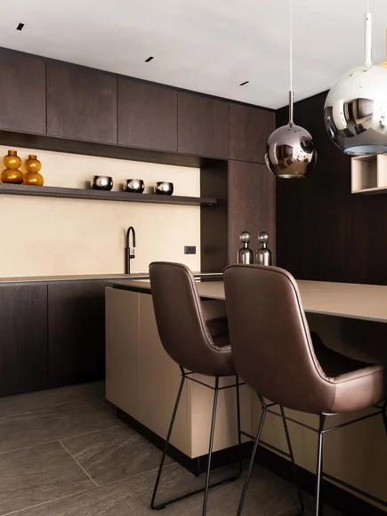 Moderne Küche mit dunklen Holzschränken und zwei braunen Barhockern