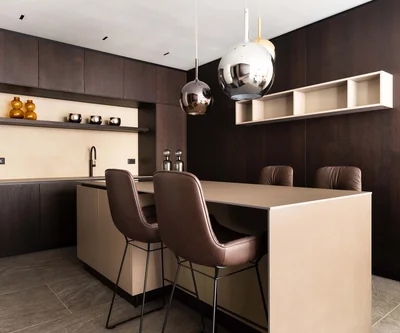 Cucina moderna con mobili in legno scuro e due sgabelli marroni