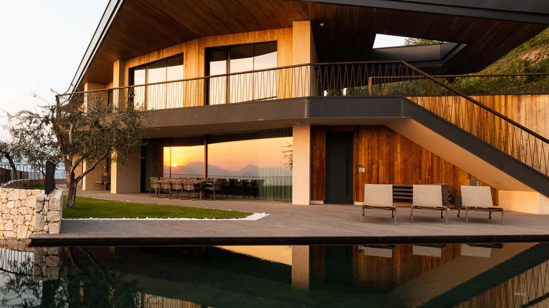 Moderne Villa mit Pool und Seeblick bei Sonnenuntergang