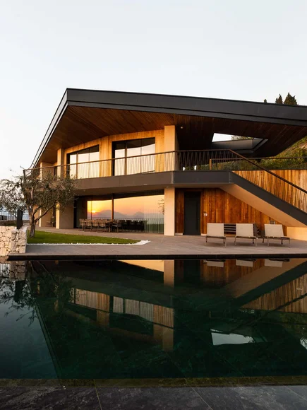 Moderne Villa mit Pool und Seeblick bei Sonnenuntergang