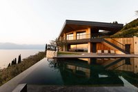 Moderne Villa mit Pool und Seeblick bei Sonnenuntergang
