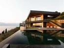 Moderne Villa mit Pool und Seeblick bei Sonnenuntergang