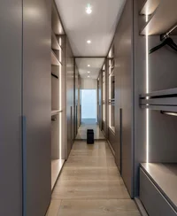 Guardaroba moderno walk-in con illuminazione indiretta e specchio