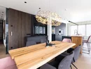 Moderner Essbereich mit Holztisch, gepolsterten Stühlen und Designerleuchte