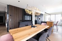 Moderner Essbereich mit Holztisch, gepolsterten Stühlen und Designerleuchte