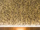 Texturierte schwarz-goldene Tierfellmusterwand mit Holzuntergrund