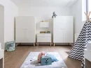 Helles Kinderzimmer mit weißen Schränken, Spielteppich und Zelt
