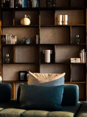Soggiorno moderno con divano verde e libreria alla luce del sole