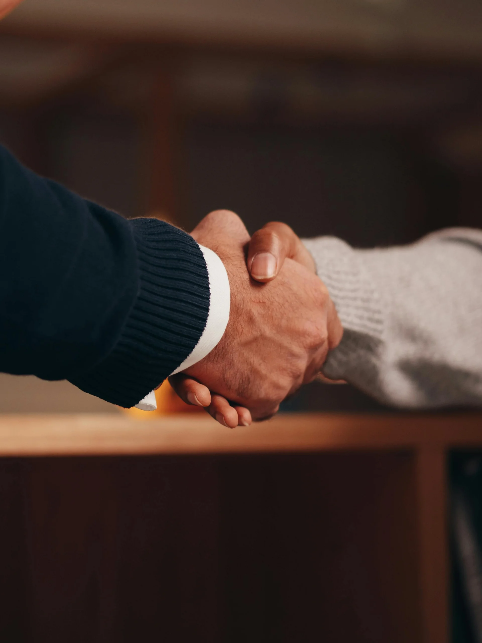 Due persone si stringono la mano in un ambiente interno
