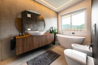 Modernes Badezimmer mit freistehender Badewanne, runden Spiegel und Holzwaschtisch