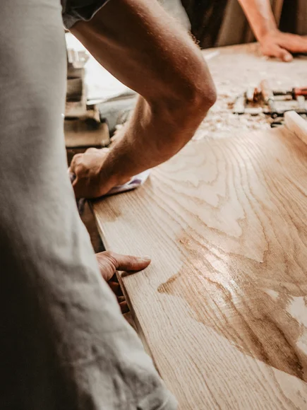 Handwerker bearbeiten ein Holzbrett in einer Werkstatt