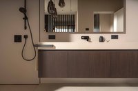 Modernes Badezimmer mit Waschbecken, großem Spiegel und schwarzer Armatur