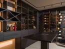 INTERIOS. Il tuo studio di interior design. Moderna enoteca con bottiglie di vino e liquori in un ambiente elegante