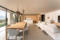 Modernes Wohnzimmer mit Esstisch, weißem Sofa und offener Küche