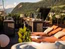 Sonnige Dachterrasse mit Liegestühlen, Außengrill und Bergblick