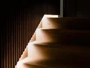 Dunkle Holztreppe mit integrierter Beleuchtung an der Wand