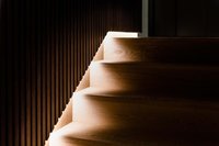 Dunkle Holztreppe mit integrierter Beleuchtung an der Wand